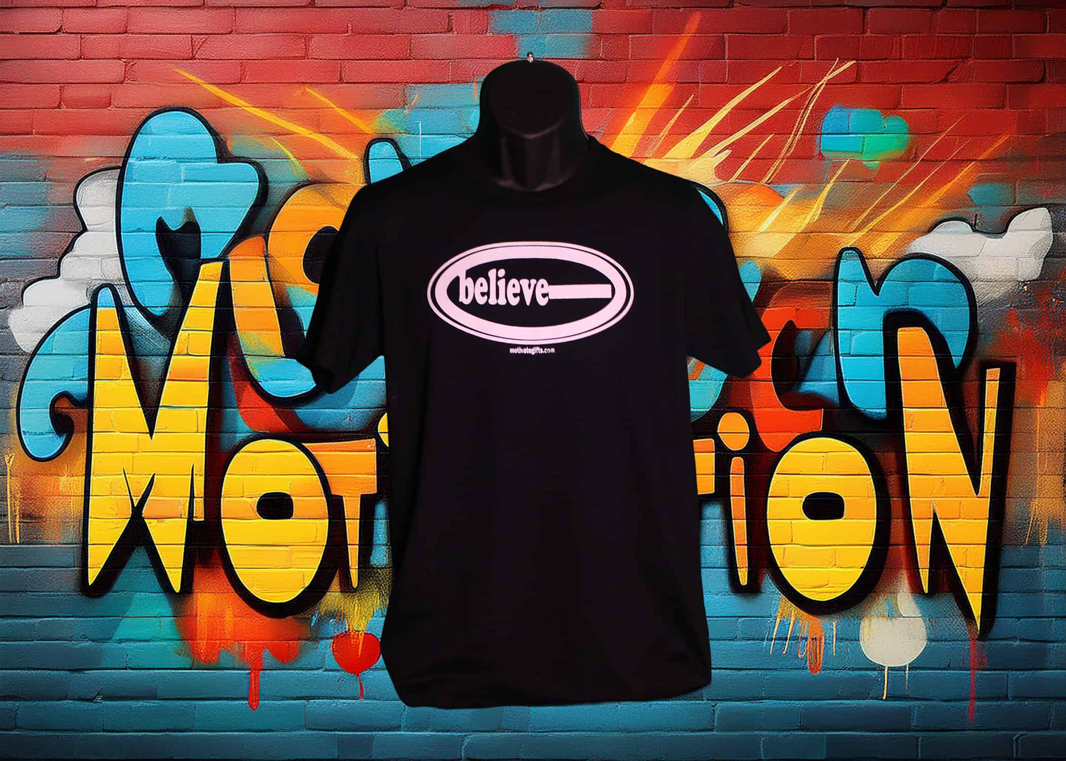 Black T-Shirt With Believe written inside an oval shape, on the front in White ink. With motivategifts.com located bottom center.